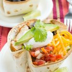 This recipe for healthy chicken taco salad is marinated and grilled chicken with shredded lettuce, creamy cilantro dressing and your favorite taco toppings, all inside a baked tortilla shell.