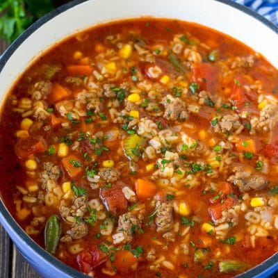 A pot of alphabet soup with ground beef and vegetables.