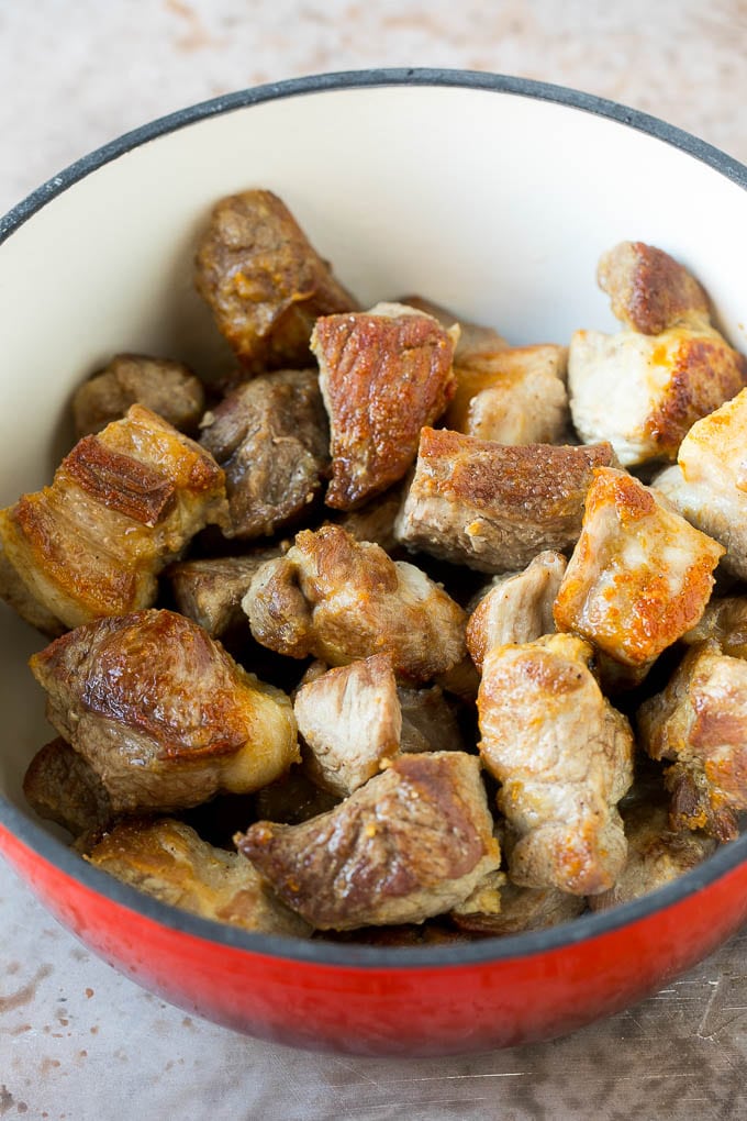 Seared pork shoulder pieces in a pot.