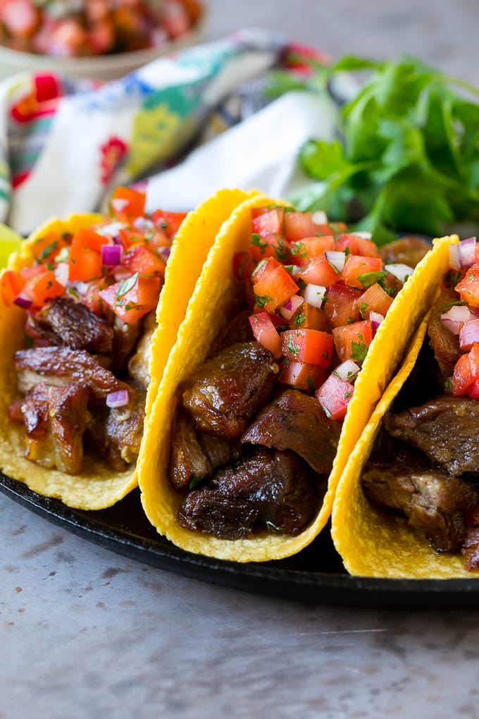 Pork carnitas tacos in corn tortillas, topped with pico de gallo.