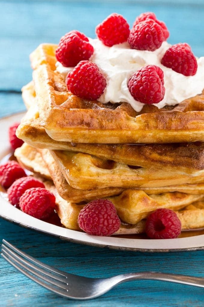 Yeast waffles topped with maple syrup, whipped cream and berries.