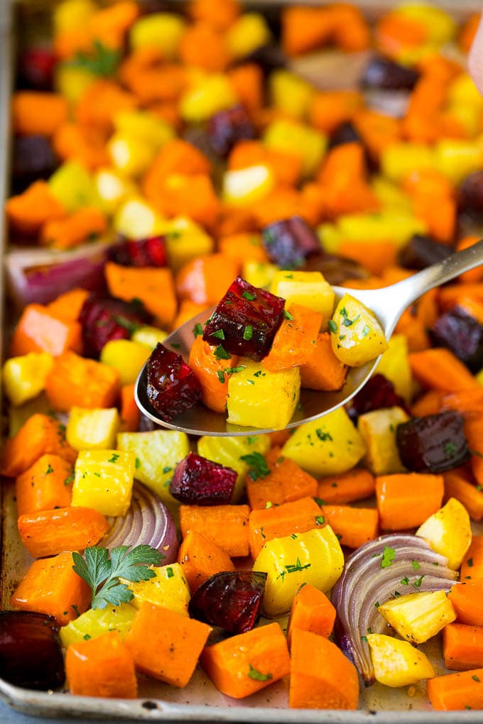 A spoon serving up a portion of roasted vegetables.