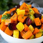 A bowl of diced roasted root vegetables topped with parsley.