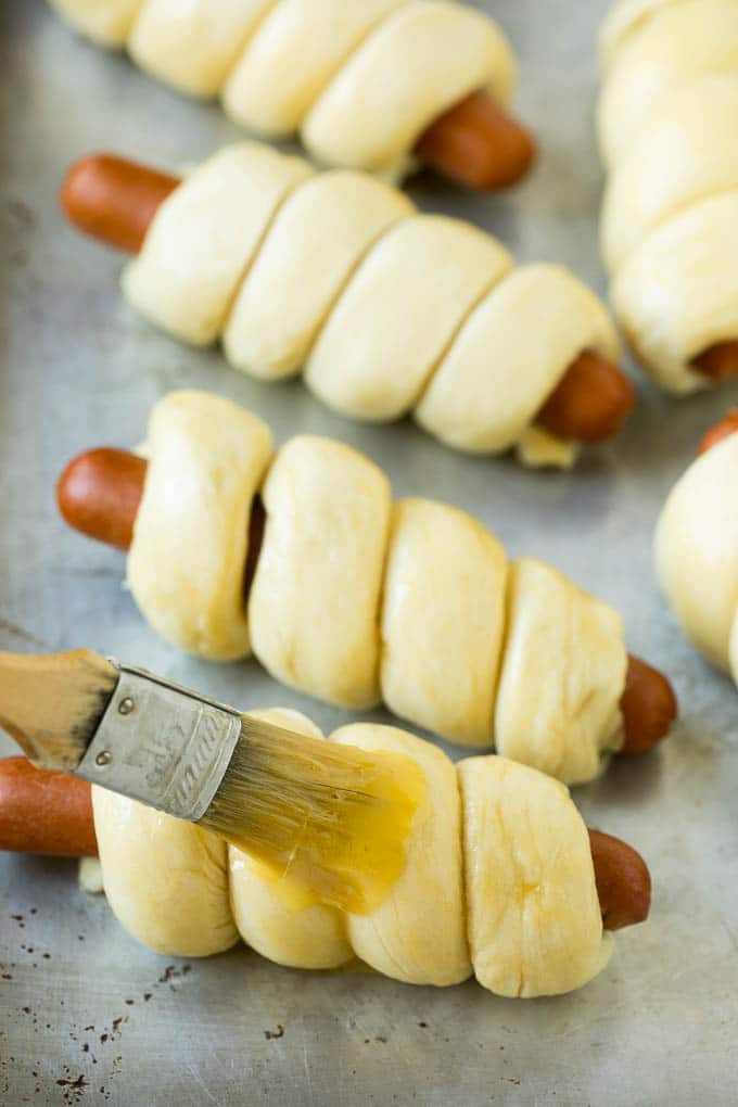 Hot dogs in dough brushed with egg wash.