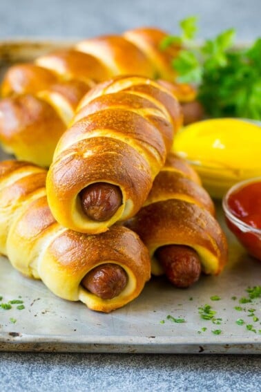 Bagel dogs served with ketchup and mustard on the side.