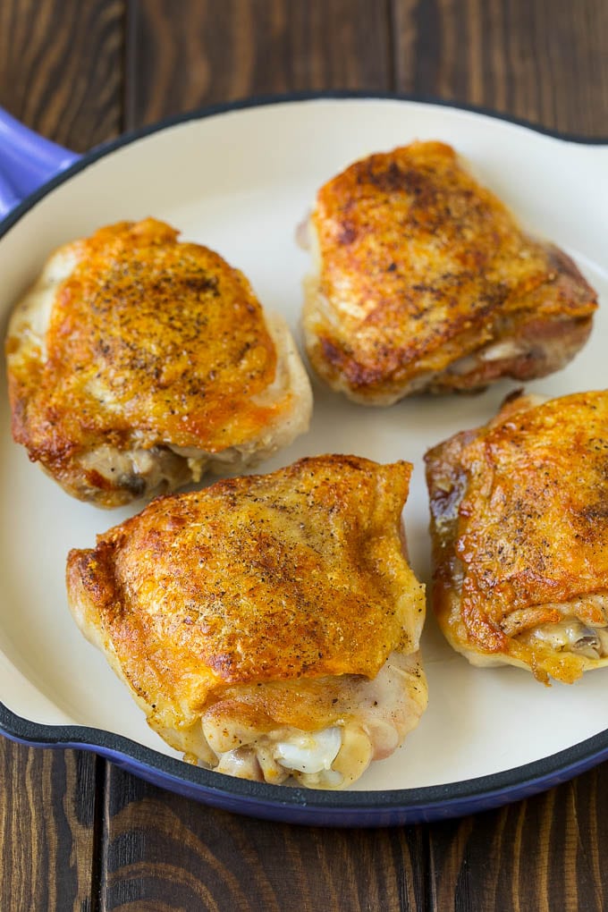 Seared chicken thighs in a skillet.