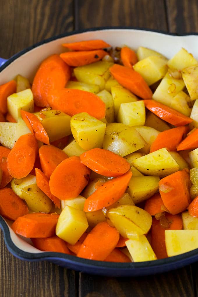 Cooked carrots and potatoes in a pan.