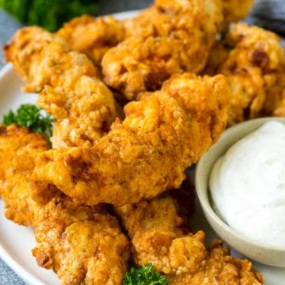 Chicken fingers on a serving plate with a side of ranch.