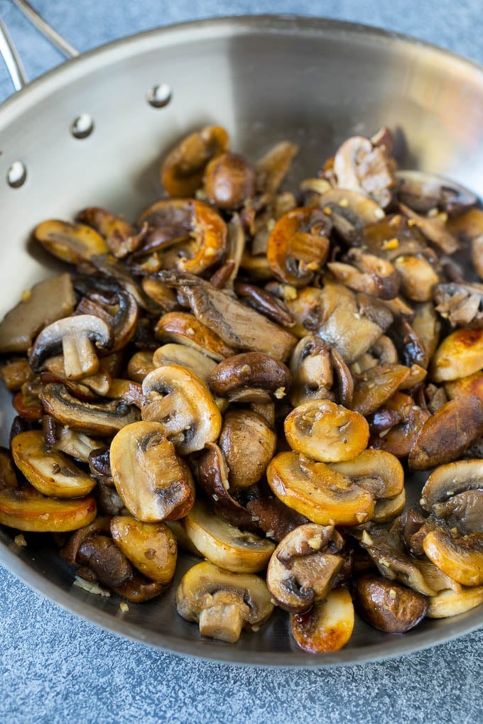 An assortment of sauteed mushrooms in a skillet.