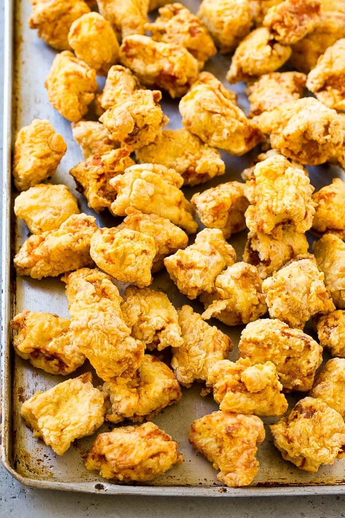 Fried chicken breast pieces on a sheet pan.