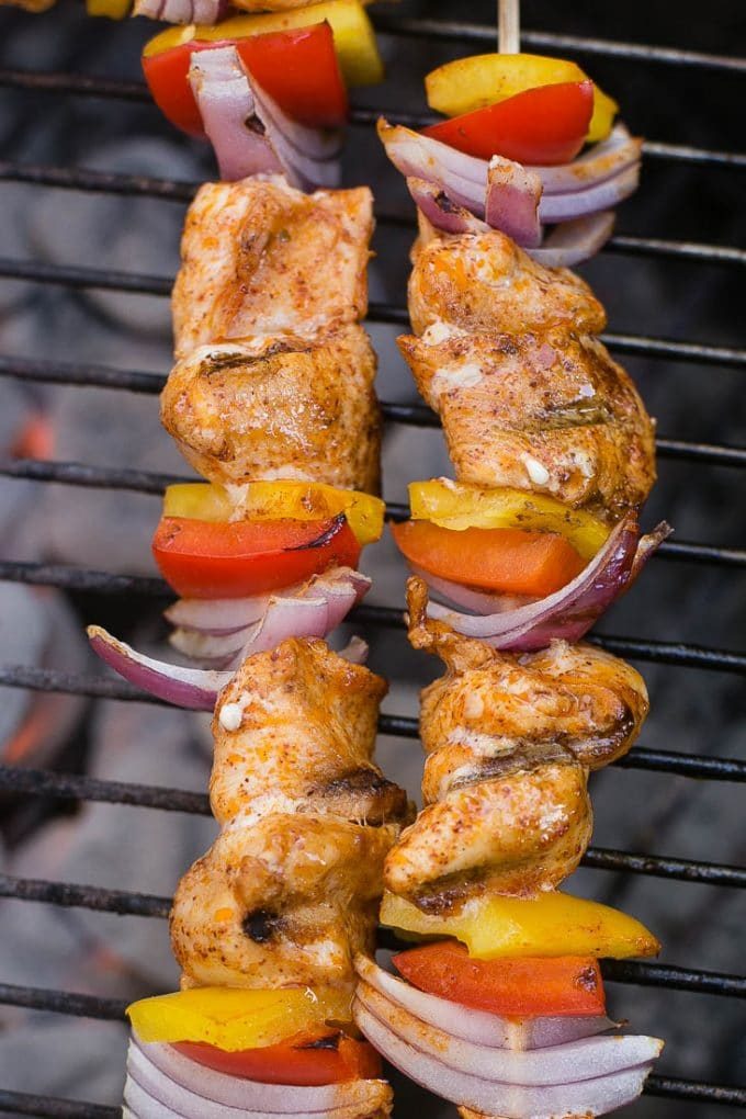 Chicken fajita skewers on a charcoal grill.