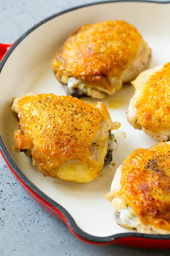 Browned chicken thighs in a skillet.