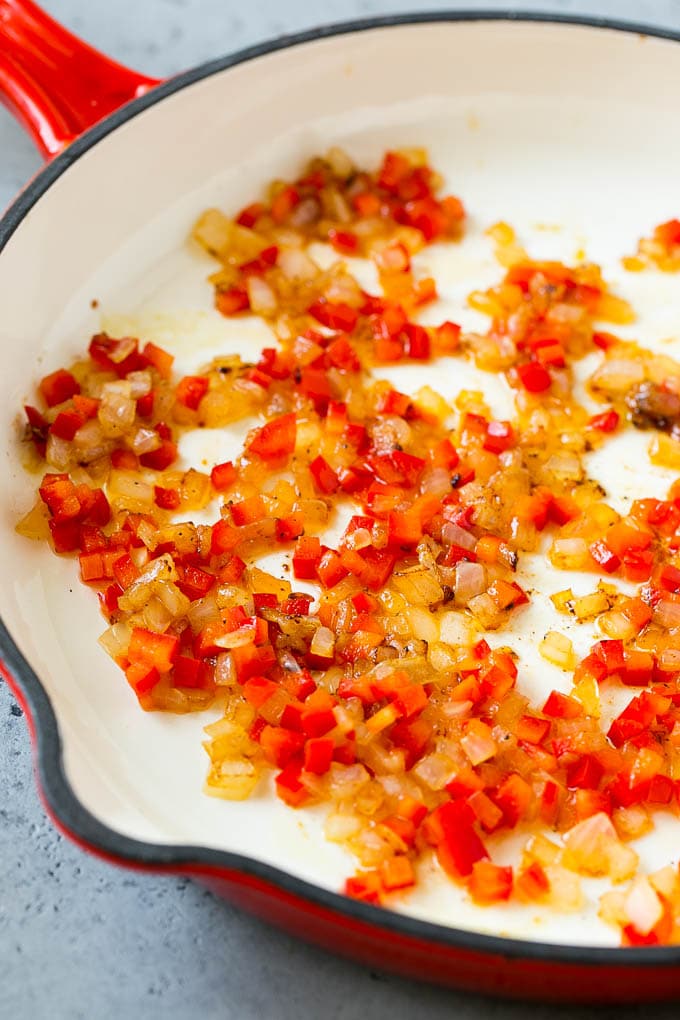 Sauteed peppers and onions in a skillet.