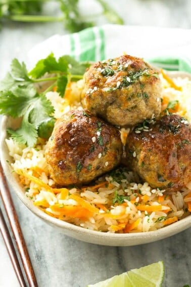 This recipe for asian turkey meatballs involves light and tender meatballs that are seasoned with asian flavors, tossed in a honey garlic sauce and served over a colorful carrot rice. It's a quick and easy weeknight meal that the whole family will love!