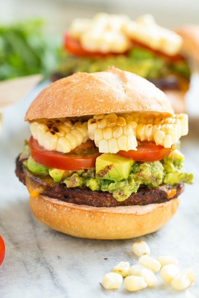 This recipe is for a black bean veggie burger with a Mexican twist! The veggie patty is layered with southwestern sauce, grilled corn, guacamole, cheese and tomatoes to create a hearty vegetarian sandwich.