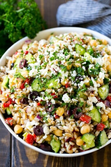 Farro salad made with cuucmber, feta cheese, olives and peppers, topped with parsley.