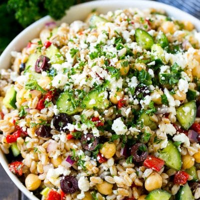 Farro salad made with cuucmber, feta cheese, olives and peppers, topped with parsley.