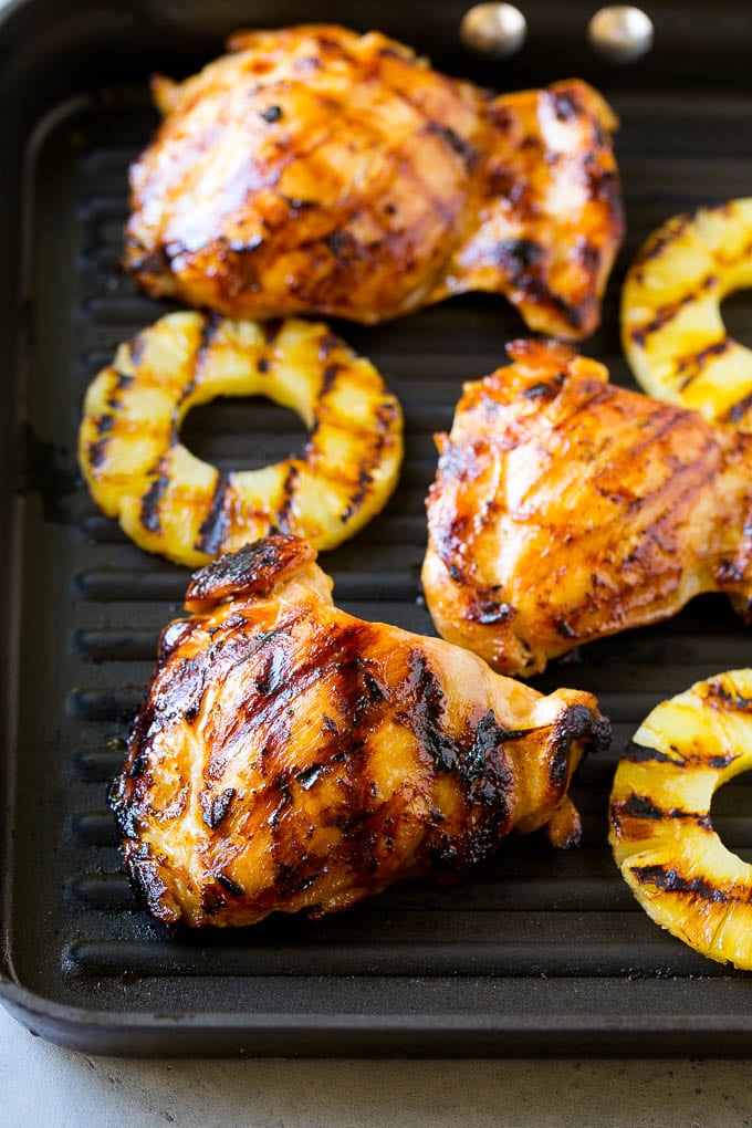 Chicken thighs and pineapple slices on a grill pan.