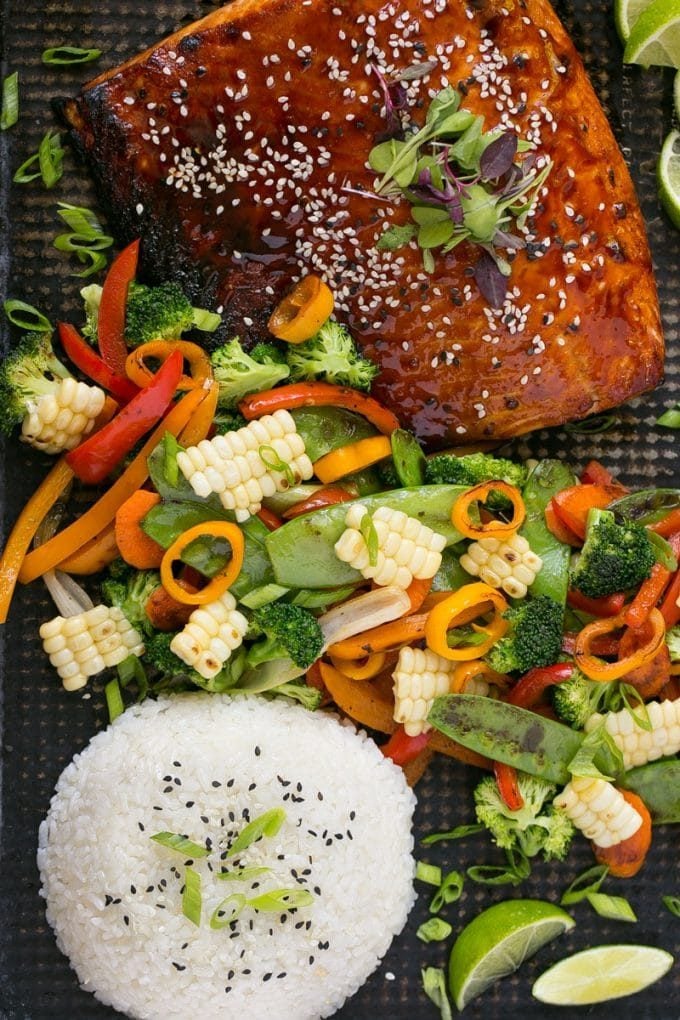 A sheet pan with hoisin glazed salmon, mixed vegetables and steamed rice.