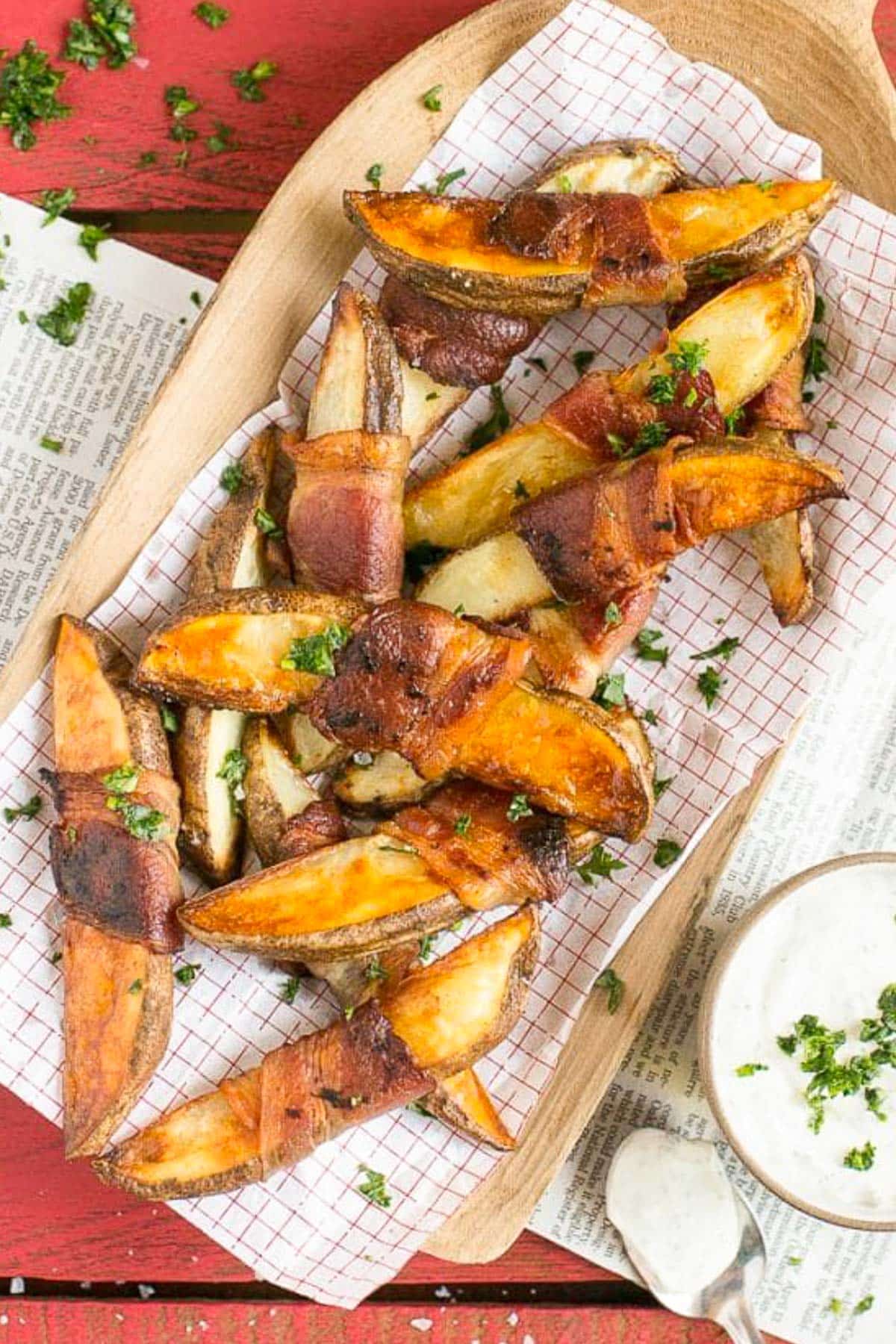 Potato wedges on a sheet of parchment paper that have been roasted.