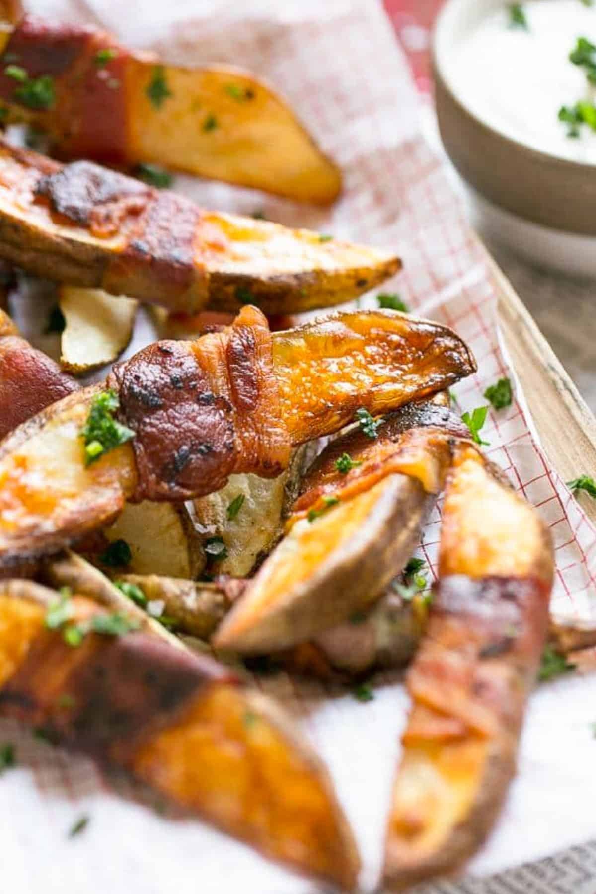 French fries wrapped in bacon and topped with parsley.