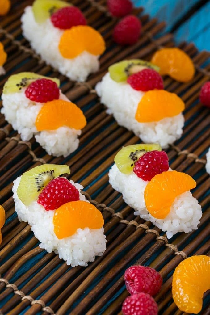 Fruit sushi topped with raspberry, orange and kiwi.