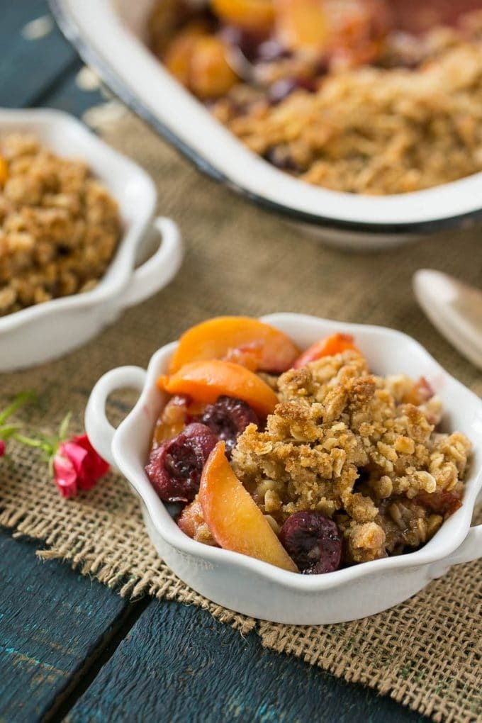 A ramekin holding a serving of fruit crisp.