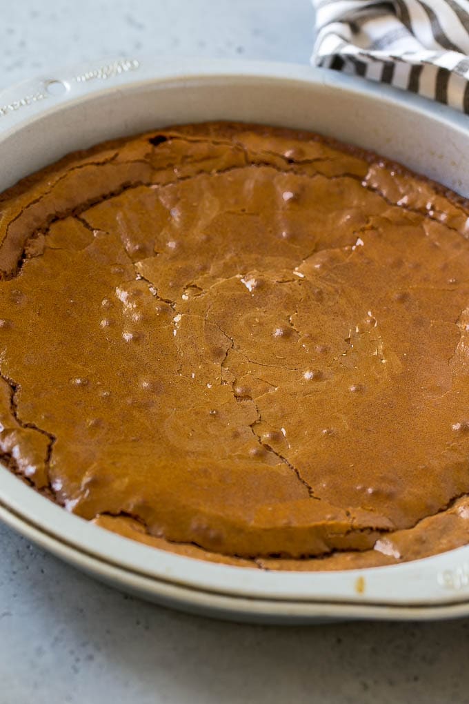 A baked brownie in a round pan.