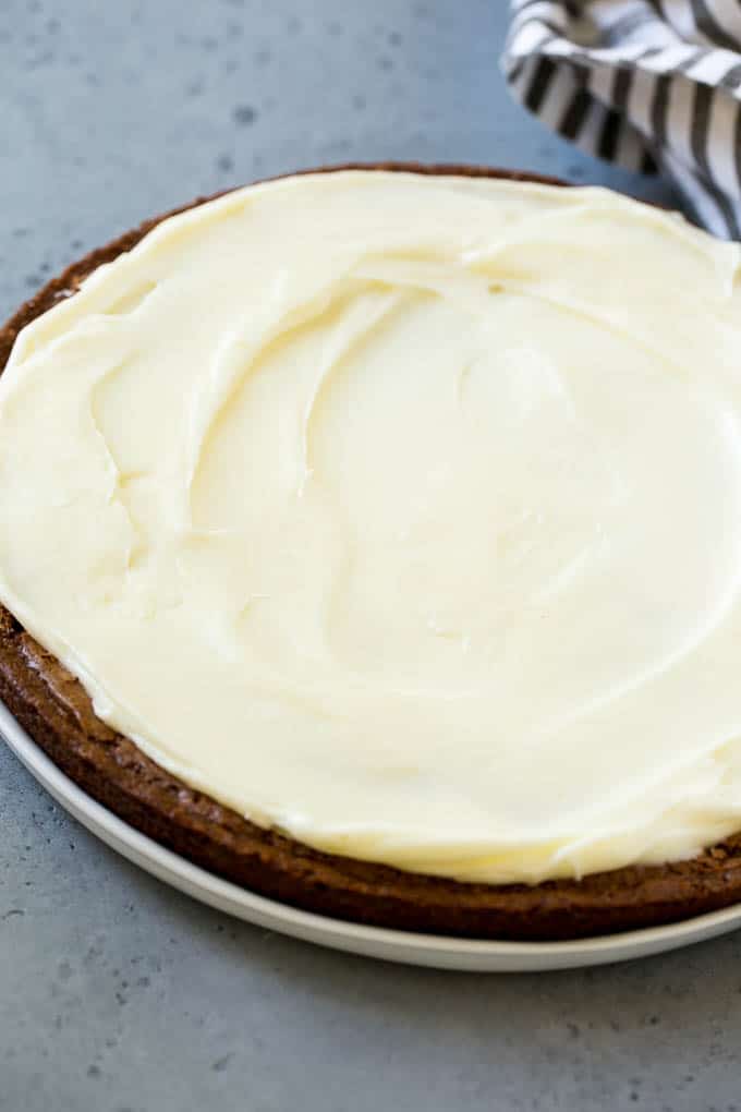 A large round brownie with cream cheese frosting.