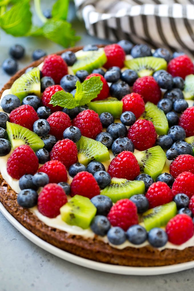 A brownie pizza topped with raspberries, blueberries and kiwis.