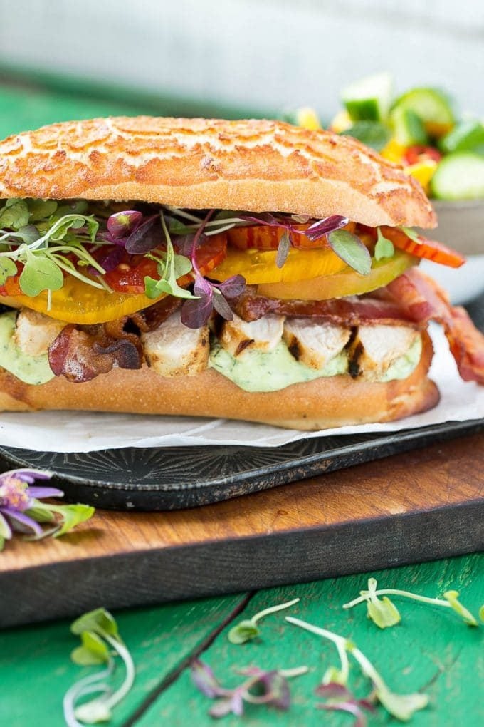 A grilled chicken sandwich with avocado ranch sauce.