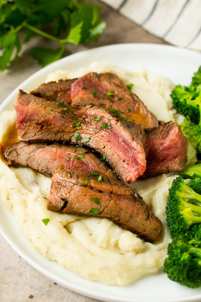Marinated flank steak served with mashed potatoes and broccoli.