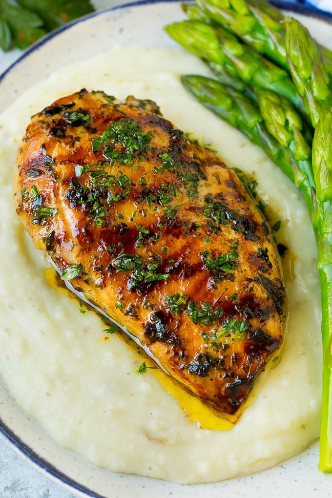 Grilled chicken breast served with mashed potatoes and asparagus.