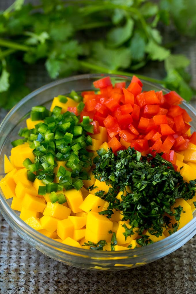 Diced mango, jalapeno, red pepper and cilantro in a bowl.