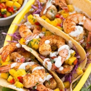 Shrimp tacos with sweet and tangy mango salsa and creamy cilantro lime sauce.