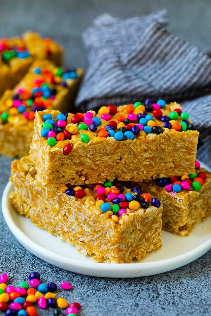 Cereal bars on a plate with colorful candy coated chocolates on top.