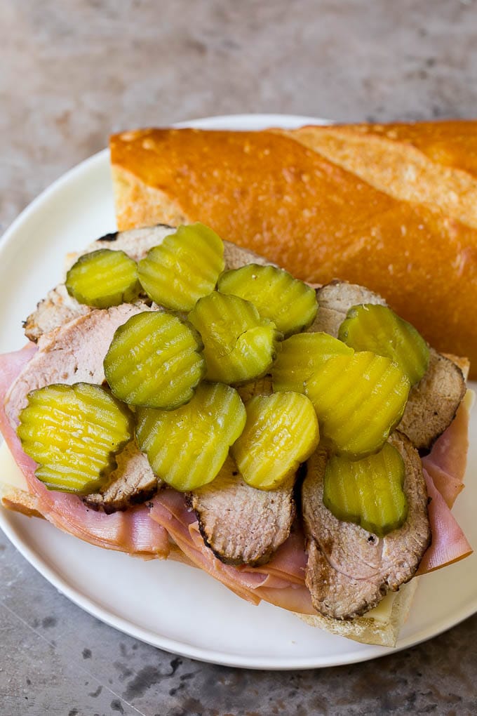 Pork, ham, cheese and pickles on a roll.