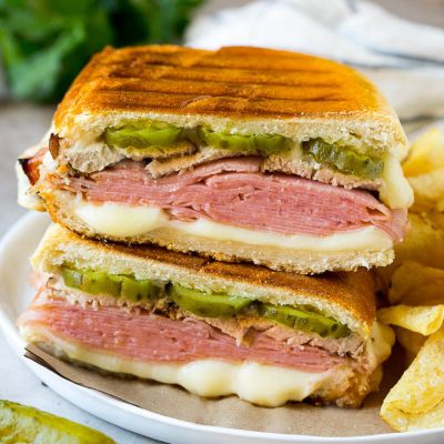A pressed Cuban sandwich with layers of ham, cheese and pickles.