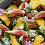 This spinach salad recipe is full of figs, roasted acorn squash, candied pecans and blue cheese and is finished off with a honey balsamic dressing.