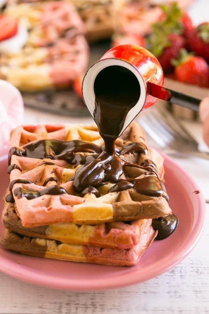 Fudge sauce poured over neapolitan waffles.