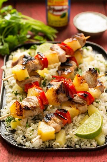 A recipe for sweet and spicy pineapple pork kebabs served on a bed of pineapple cilantro rice. #KingofFlavor AD @ElYucateco