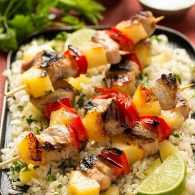 A recipe for sweet and spicy pineapple pork kebabs served on a bed of pineapple cilantro rice. #KingofFlavor AD @ElYucateco