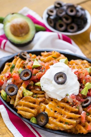Waffle fries are smothered in nacho toppings for a fun and delicious snack. #FarmtoFlavor Ad