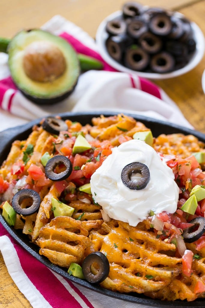 Waffle fries are smothered in nacho toppings for a fun and delicious snack.