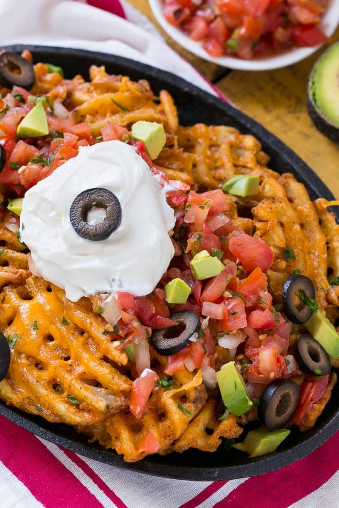 Waffle fries are smothered in nacho toppings for a fun and delicious snack.