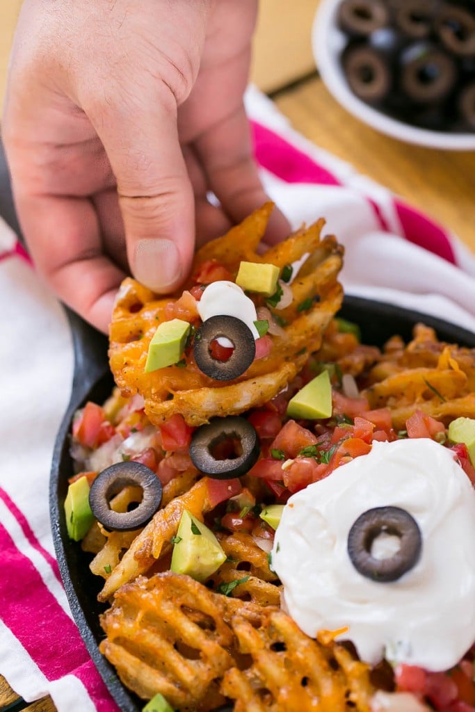 Waffle fries are smothered in nacho toppings for a fun and delicious snack.