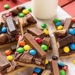 These candy bar blondies are a chewy brown sugar cookie base topped with rich chocolate frosting and your favorite candy.