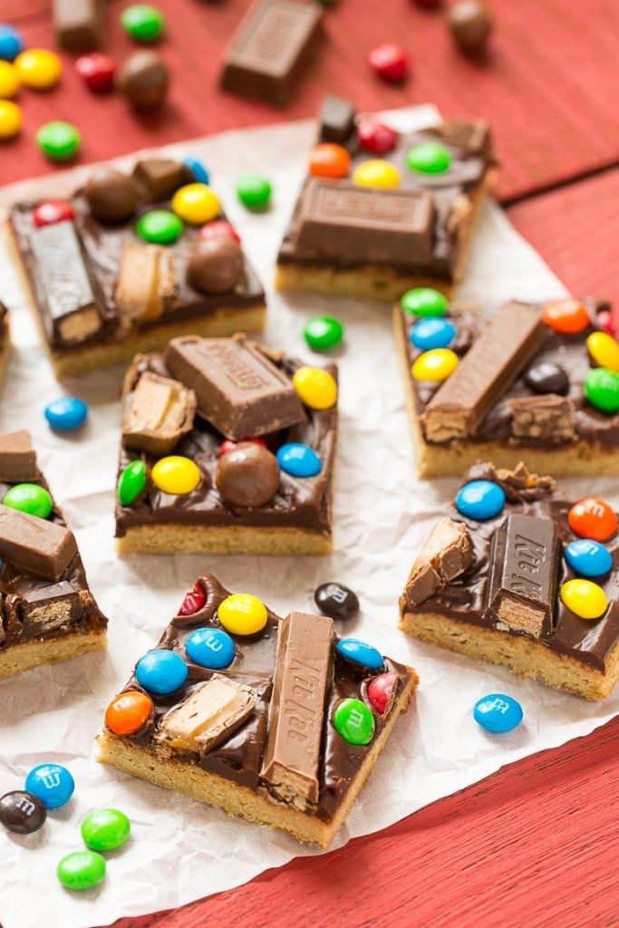 These candy bar blondies are a chewy brown sugar cookie base topped with rich chocolate frosting and your favorite candy.