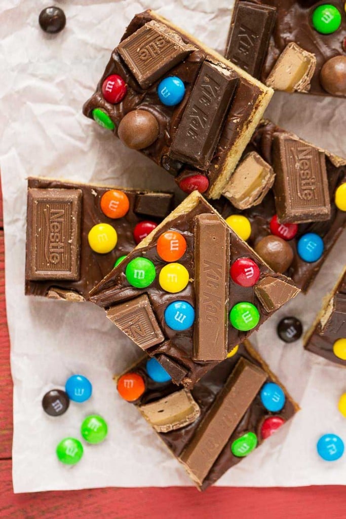 These candy bar blondies are a chewy brown sugar cookie base topped with rich chocolate frosting and your favorite candy.