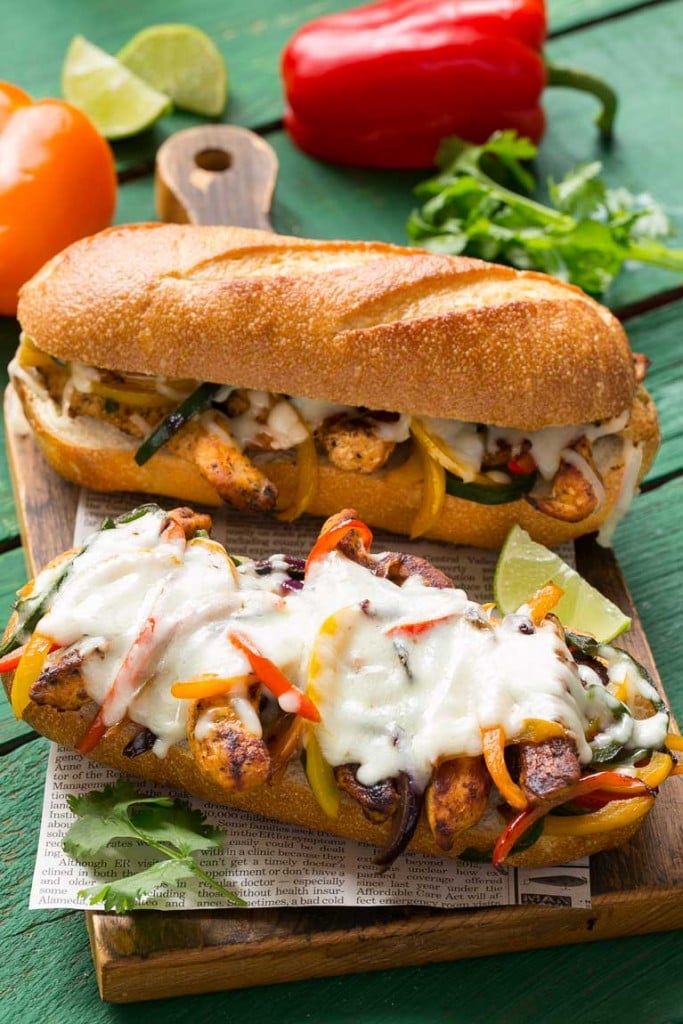 These fajita chicken cheesesteak sandwiches are full of spiced chicken, peppers and lots of cheese, all on a toasted roll.